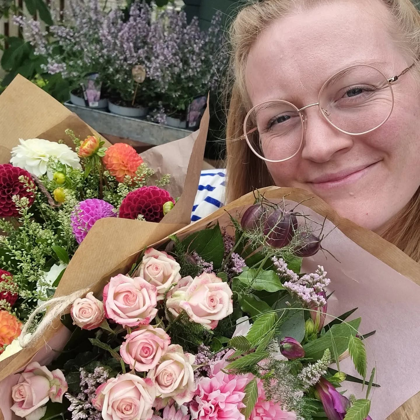 Merete smiler med sine buketter af rosa roser og farverige georginer i Den lille blomsterbod